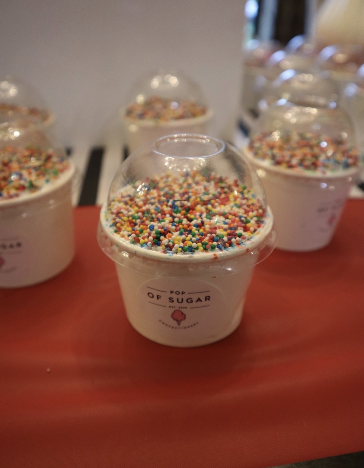 Close up of a Pop of Sugar sprinkle topped dessert cup on the graduation table