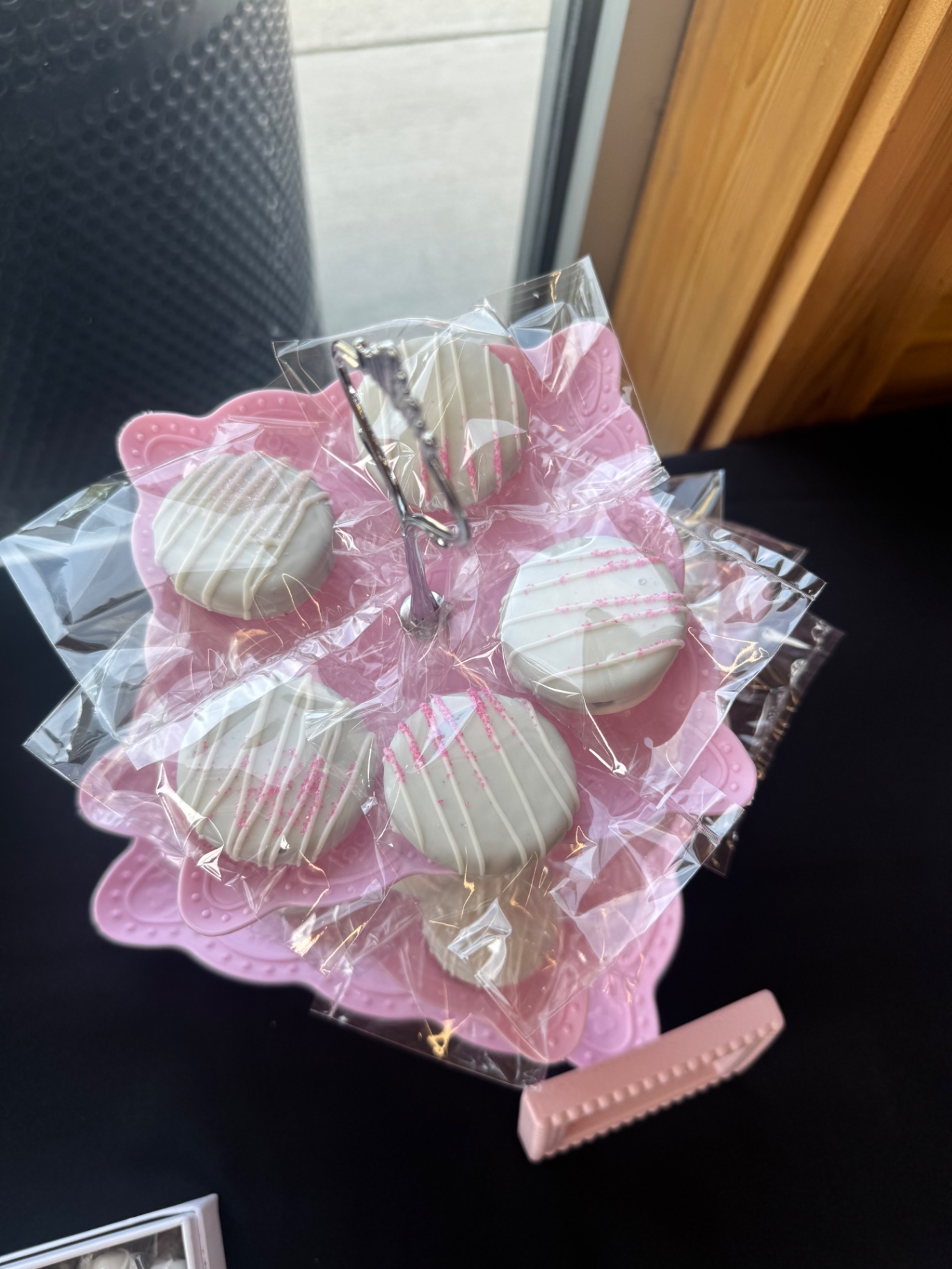 Pink dessert stand holding white chocolate graduation party treats