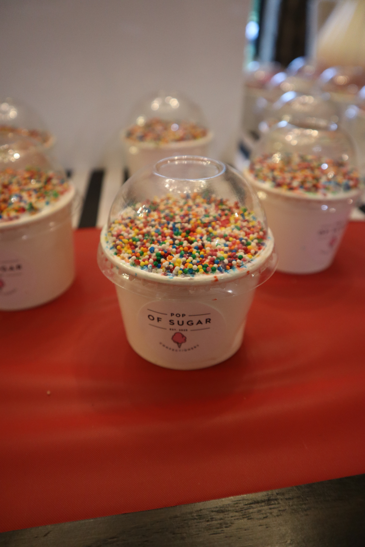 Dot Cake covered in sprinkles under a dome