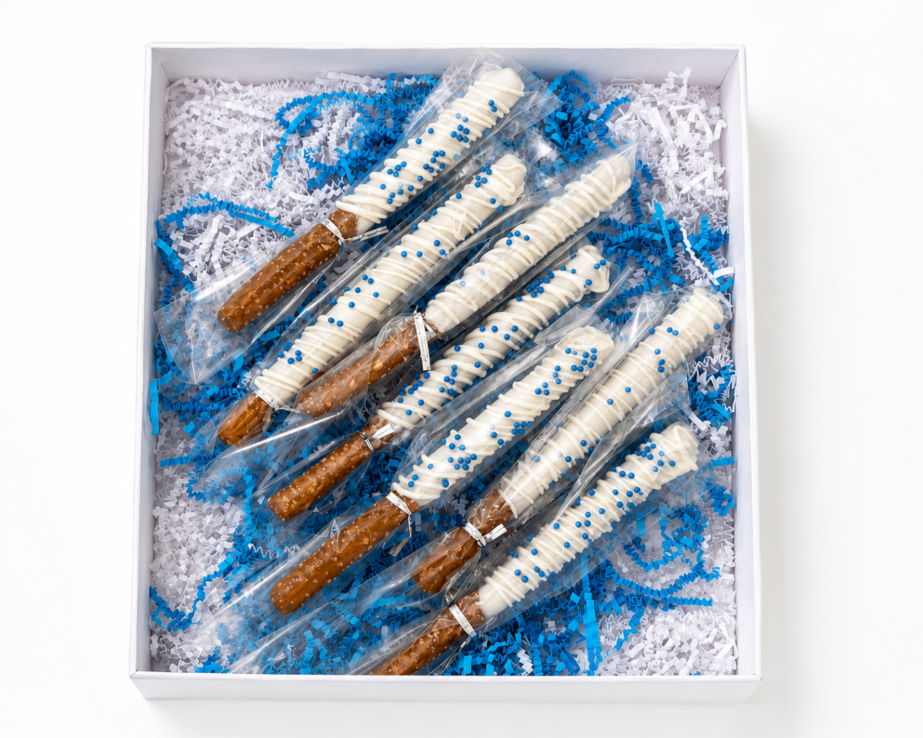 Boxed graduation party pretzel rods with blue and white crinkle paper