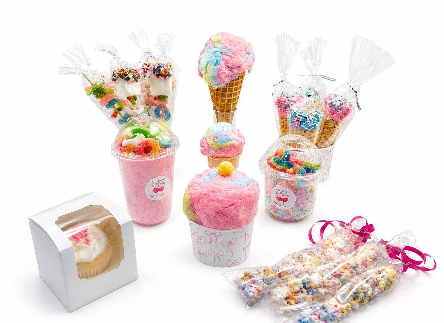 A spread of Pop of Sugar party treats including cotton candy cups, cones, candy kabobs, popcorn sticks and boxed cupcakes